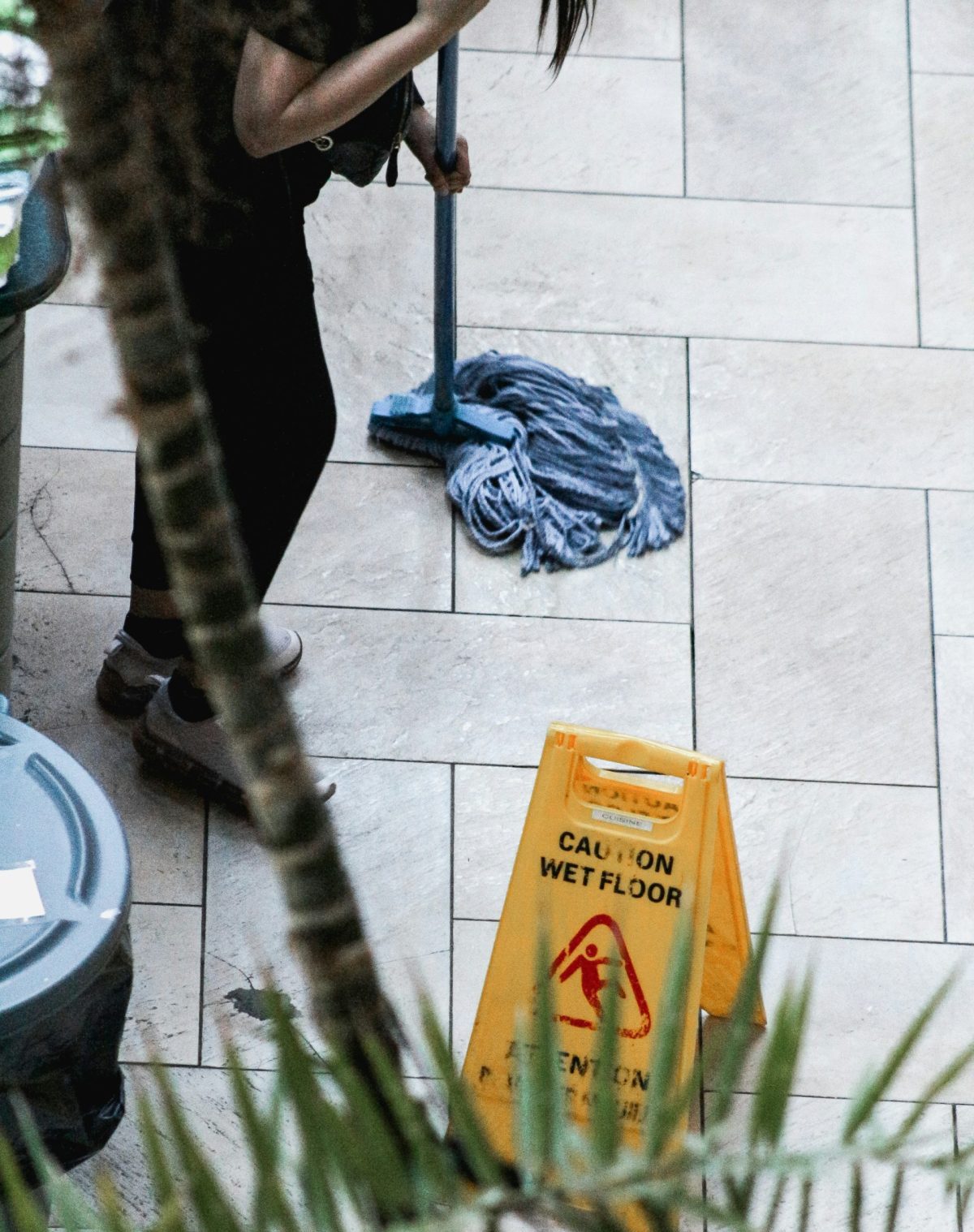 a woman sweeping the floor with a mop